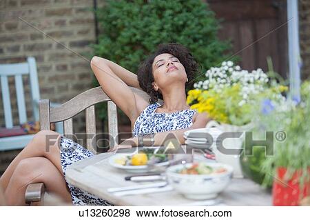 "Mid adult woman relaxing at dining table, outdoors" View Large Photo Image Stock Photo - "Mid adult woman relaxing at dining table, outdoors". Fotosearch