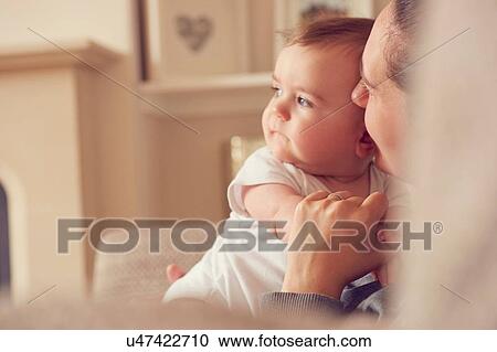 Stock Image - Mother and baby boy playing in living room. Fotosearch