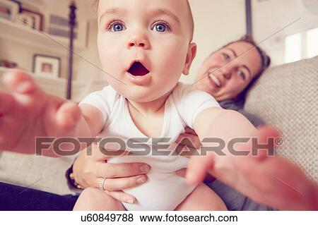 Mother and baby boy playing in living room View Large Photo Image Stock Photo - Mother and baby boy playing in living room. Fotosearch