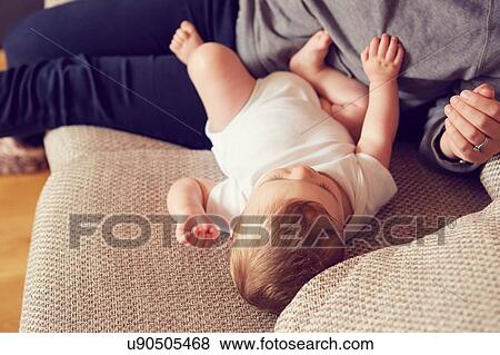 Stock Photo - Mother and baby boy playing in living room. Fotosearch