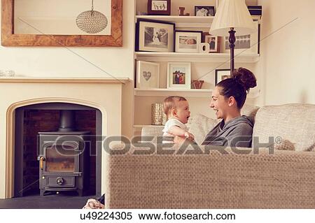 Stock Photography - Mother and baby boy playing in living room. Fotosearch