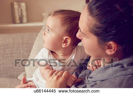 Stock Photography - Mother and baby boy playing in living room. Fotosearch