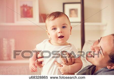 Mother and baby boy playing in living room View Large Photo Image Stock Photography - Mother and baby boy playing in living room. Fotosearch