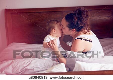 Mother and baby boy playing on bed View Large Photo Image Stock Image - Mother and baby boy playing on bed. Fotosearch