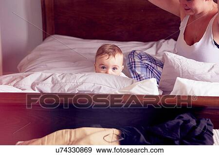 Mother and baby boy playing on bed View Large Photo Image Stock Photo - Mother and baby boy playing on bed. Fotosearch