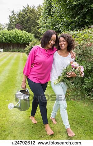 Mother and grown daughter in garden together View Large Photo Image Stock Image - Mother and grown daughter in garden together. Fotosearch