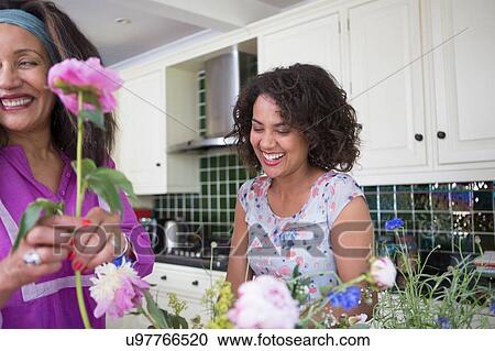 "Mother and grown daughter in kitchen, arranging flowers" View Large Photo Image Stock Image - "Mother and grown daughter in kitchen, arranging flowers". Fotosearch