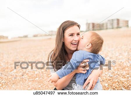Mother and young son playing on pebble beach View Large Photo Image Stock Photo - Mother and young son playing on pebble beach. Fotosearch