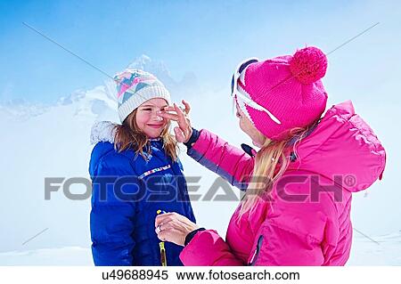Stock Photography - "Mother applying sun cream on daughter's face, Chamonix, France". Fotosearch