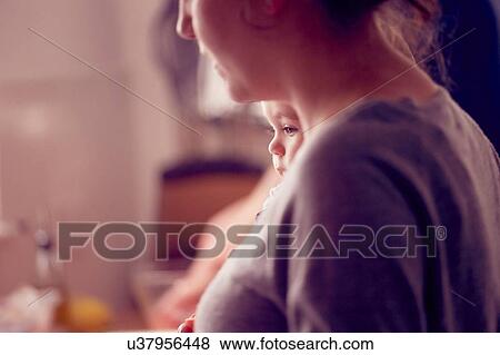 Mother carrying baby boy in kitchen View Large Photo Image Stock Photo - Mother carrying baby boy in kitchen. Fotosearch