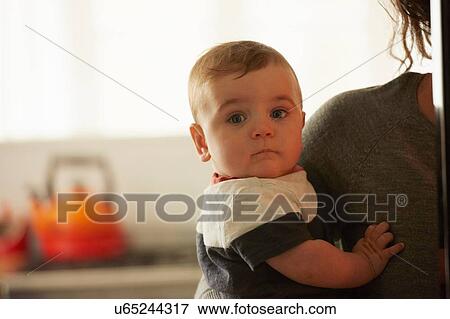 Mother carrying baby boy in kitchen View Large Photo Image Stock Photo - Mother carrying baby boy in kitchen. Fotosearch