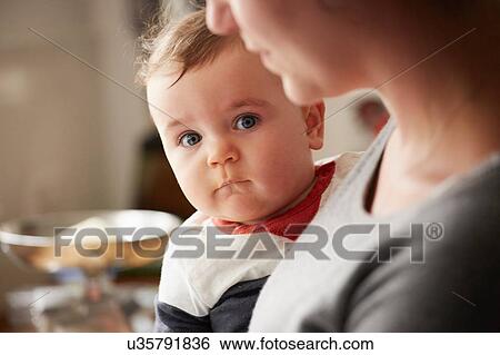 Mother carrying baby boy in kitchen View Large Photo Image Stock Photograph - Mother carrying baby boy in kitchen. Fotosearch