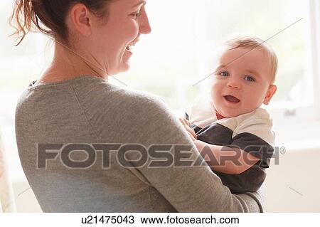Mother carrying baby boy View Large Photo Image Stock Image - Mother carrying baby boy. Fotosearch