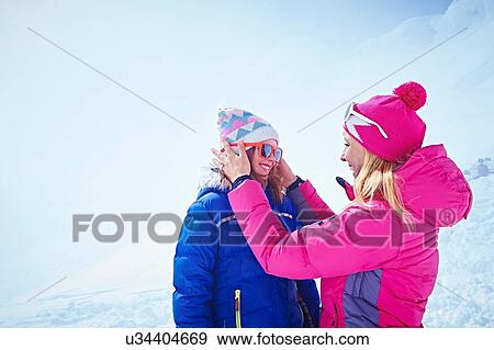 Stock Photo - "Mother helping daughter with sunglasses, Chamonix, France". Fotosearch