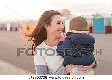 Stock Photograph - Mother holding young son at beach. Fotosearch