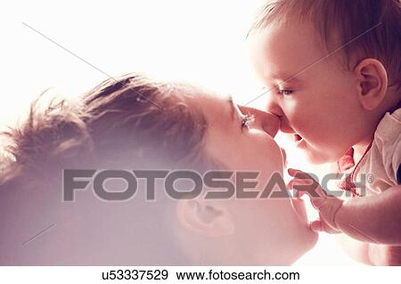 Stock Photo - Mother rubbing noses with baby boy. Fotosearch