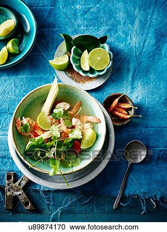 Stock Image - Overhead view of kaffir lime tom yum soup. Fotosearch