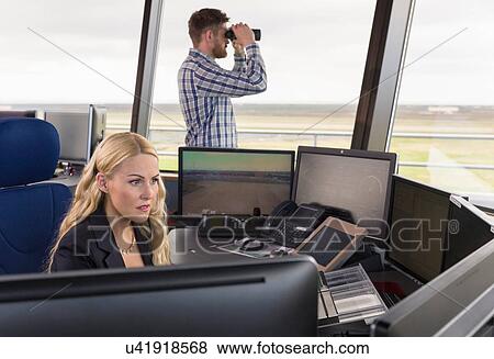 Stock Photo - "People working in air traffic control tower, monitoring screens and looking through binoculars". Fotosearch