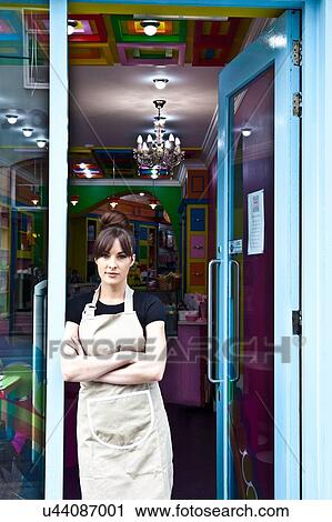 "Portrait of female worker in cake shop, standing in doorway of shop, looking out" View Large Photo Image Stock Image - "Portrait of female worker in cake shop, standing in doorway of shop, looking out". Fotosearch
