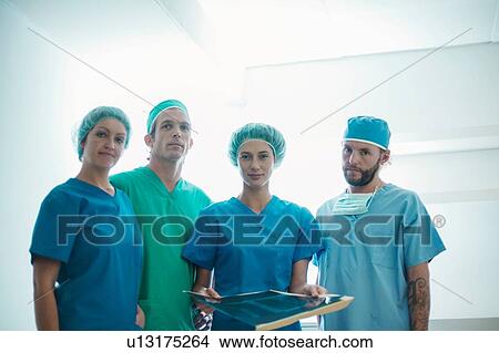 Picture - Portrait of four male and female orthopedic surgeons holding x-ray image. Fotosearch