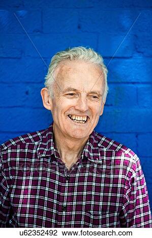 "Portrait of happy senior man, blue brick wall in background" View Large Photo Image Stock Image - "Portrait of happy senior man, blue brick wall in background". Fotosearch