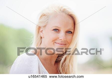 Portrait of long haired young blonde woman looking at camera smiling View Large Photo Image Stock Photography - Portrait of long haired young blonde woman looking at camera smiling. Fotosearch
