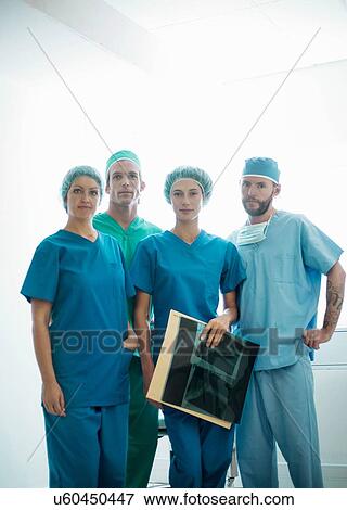 Stock Photo - Portrait of male and female orthopedic surgeons holding x-ray image. Fotosearch