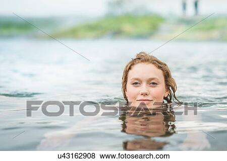 "Portrait of serene young woman swimming in Secret Lagoon hot spring (Gamla Laugin), Fludir, Iceland" View Large Photo Image Stock Photo - "Portrait of serene young woman swimming in Secret Lagoon hot spring (Gamla Laugin), Fludir, Iceland". Fotosearch