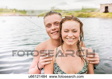 "Portrait of smiling young couple standing in Secret Lagoon hot spring (Gamla Laugin), Fludir, Iceland" View Large Photo Image Picture - "Portrait of smiling young couple standing in Secret Lagoon hot spring (Gamla Laugin), Fludir, Iceland". Fotosearch