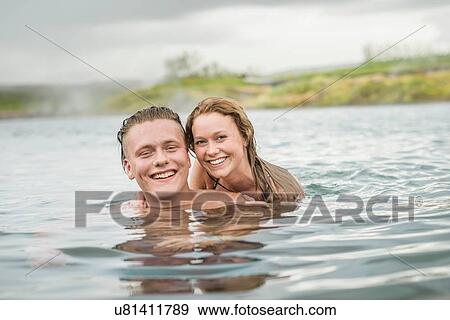 "Portrait of smiling young couple relaxing in Secret Lagoon hot spring (Gamla Laugin), Fludir, Iceland" View Large Photo Image Stock Photo - "Portrait of smiling young couple relaxing in Secret Lagoon hot spring (Gamla Laugin), Fludir, Iceland". Fotosearch