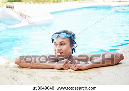 Stock Photo - Portrait of smiling young man with wet hair in swimming pool. Fotosearch
