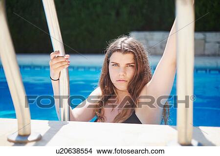 Picture - Portrait of teenage girl holding swimming pool railings. Fotosearch