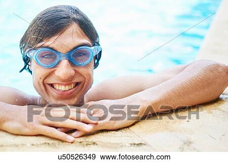 Stock Photo - Portrait of young man wearing goggles in swimming pool. Fotosearch