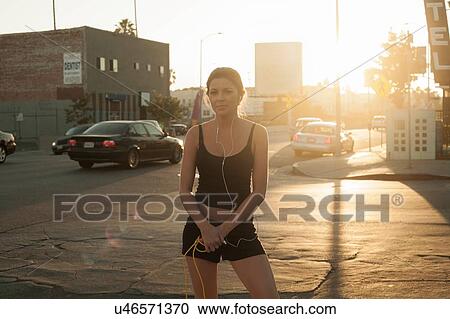 Portrait of young woman wearing earphones and holding skipping rope View Large Photo Image Stock Image - Portrait of young woman wearing earphones and holding skipping rope. Fotosearch