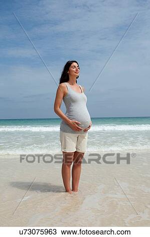 Pregnant mid adult woman standing with eyes closed in sea View Large Photo Image Stock Image - Pregnant mid adult woman standing with eyes closed in sea. Fotosearch
