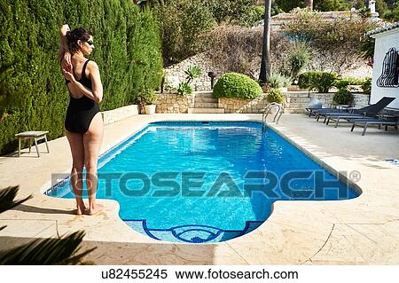 Rear view of mature woman wearing bathing costume standing poolside View Large Photo Image Stock Photography - Rear view of mature woman wearing bathing costume standing poolside. Fotosearch