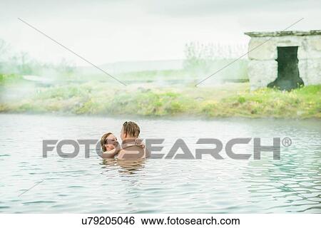 Stock Photograph - "Romantic young couple relaxing in Secret Lagoon hot spring (Gamla Laugin), Fludir, Iceland". Fotosearch