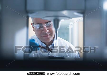 Stock Photo - Scientist uses rheology machine to test graphene ink in graphene processing factory. Fotosearch