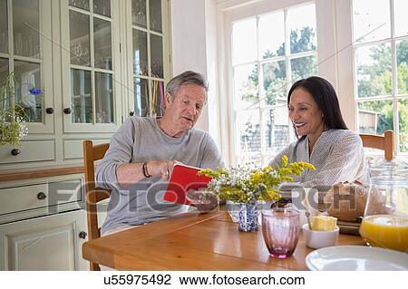 "Senior couple in kitchen, looking at digital tablet" View Large Photo Image Stock Image - "Senior couple in kitchen, looking at digital tablet". Fotosearch