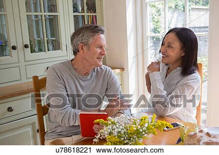 "Senior couple in kitchen, looking at digital tablet" View Large Photo Image Stock Image - "Senior couple in kitchen, looking at digital tablet". Fotosearch