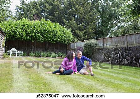 Senior couple sitting on grass in garden View Large Photo Image Stock Photo - Senior couple sitting on grass in garden. Fotosearch