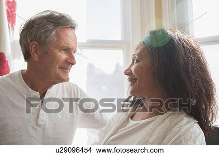 "Senior couple sitting together, face to face, smiling" View Large Photo Image Picture - "Senior couple sitting together, face to face, smiling". Fotosearch