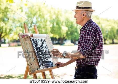 Stock Photo - "Senior man drawing in park, Hackney, London". Fotosearch