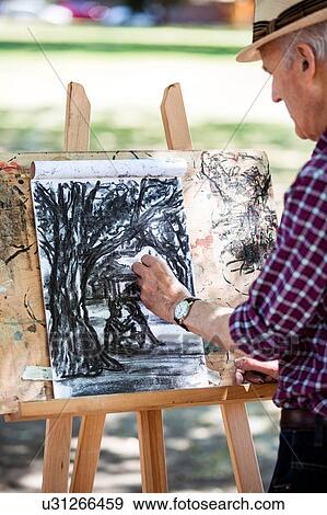 "Senior man drawing in park, Hackney, London" View Large Photo Image Stock Photo - "Senior man drawing in park, Hackney, London". Fotosearch