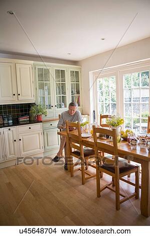 "Senior man in kitchen, looking at digital tablet" View Large Photo Image Picture - "Senior man in kitchen, looking at digital tablet". Fotosearch