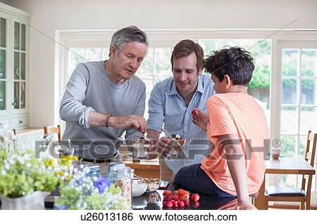 Stock Photograph - Senior man making granola with son and grandson. Fotosearch