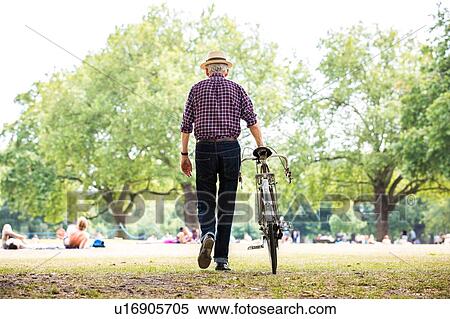 Stock Photography - "Senior man with bicycle in park, Hackney, London". Fotosearch