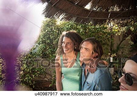 Stock Photo - Smiling couple at poolside party. Fotosearch