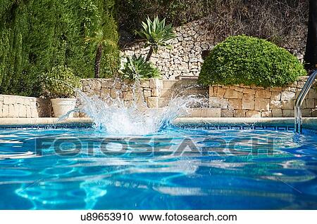 Stock Image - Splash in holiday apartment swimming pool. Fotosearch