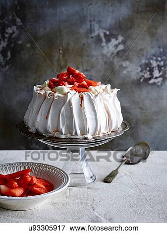 Strawberry covered pavlova on glass cake stand with cake server and bowl of strawberries View Large Photo Image Stock Photo - Strawberry covered pavlova on glass cake stand with cake server and bowl of strawberries. Fotosearch